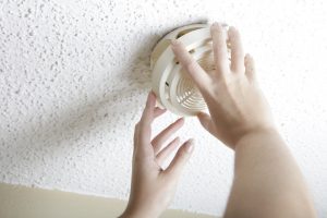 female-hands-opening-smoke-detector-to-change-battery